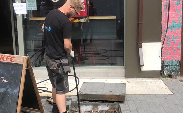 Aquevo engineer jetting a drain outside a shop
